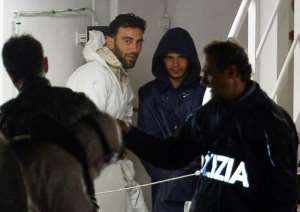 Mohammed Ali Malek 2nd L, one of the survivors and understood to be the captain of the boat that overturned off the coasts of Libya, seen onboard the Italian Coast Guard vessel Bruno Gregoretti, in April 2015.  By Alberto Pizzoli AFPFile