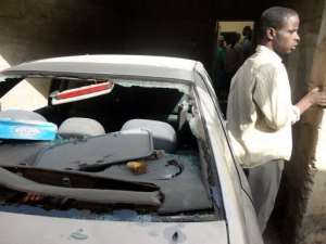 A brother of a suspected member of the Nigerian Islamist group Boko Haram, standsnext to a bullet-riddled car.  By Aminu Abubakar (AFP/File)