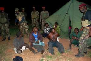 Prisoners from former Mozambican rebel movement Renamo sit on the ground with government soldiers guarding them in Gorongosa on October 17, 2013.  By Maria Celeste Mac' Arthur AFPFile