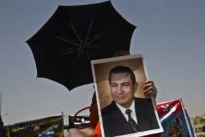 A supporter of Hosni Mubarak holds a portrait of him outside the court in Cairo on June 8, 2013 during his retrial.  By Khaled Desouki (AFP/File)
