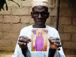 Sani Garba, 55, holds the picture of his 14-year-old daughter-in-law Wasila Tasi'u on August 10, 2014 inside her abandoned matrimonial home in the village of Unguwar Yansoro, in northern Nigerian.  By Aminu Abubakar AFPFile