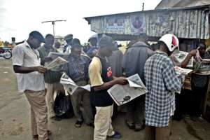 Men gather to read newspapers in Yenagoa, Nigeria, on January 27, 2006.  By Pius Utomi Ekpei AFPFile