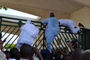 Nigerian parliament members climb the assembly gate, which was closed by security forces, in Abuja on November 20, 2014.  By  AFP