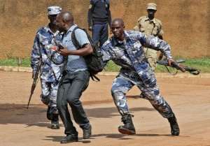 Uganda policemen arrest a journalist in Kampala, on May 28, 2013.  By Isaac Kasamani AFP