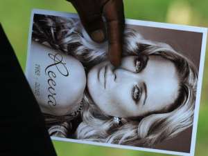 A relative of Reeva Steenkamp holds the funeral ceremony program for her in Port Elizabeth on February 19, 2013.  By Alexander Joe AFPFile