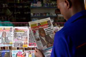 A man reads one of Uganda's local dailies in Kampala on February 25, 2014.  By Isaac Kasamani AFPFile