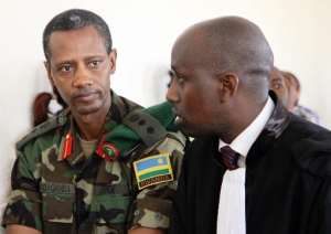 Tom Byabagamba -- the former chief of the Rwandan presidential guard -- listens to one of his lawyers before his hearing at the military court in Kigali, on August 29, 2014.  By Stephanie Aglietti AFP