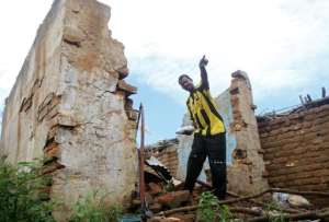 A file picture of a Sudanese man pointing to the damage caused by fighting between government forces and ex-rebels in Kadugli, in South Kordofan on October 21, 2011.  By Ashraf Shazly AFPFile