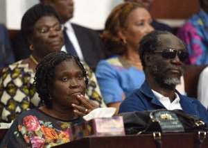 Simone Gbagbo L, Ivory Coast's former first lady, sits next to former Ivorian Prime Minister Gilbert Ake N'Gbo in the dock at the Court of Justice in Abidjan on December 26, 2014 for the start of their trial.  By Sia Kambou AFPFile
