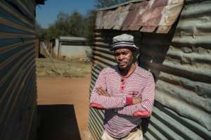 Mohlaudi Mohlaudi stands outside his house in Marikana, where in 2012 police opened fire on striking platinum workers, killing 34 miners and wounding dozens more.  By Mujahid Safodien AFP