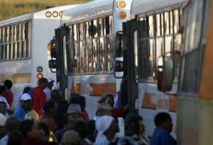 Commuters climb on to buses at Khayelitsha township on the outskirts of Cape Town.  By Rodger Bosch AFPFile