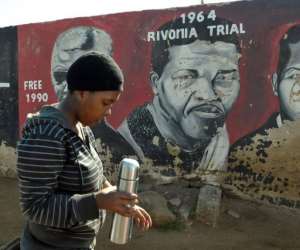 A resident walks past a mural of Nelson Mandela in Soweto, where he once lived, on June 24, 2013.  By Alexander Joe (AFP)