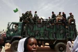 A Sudanese girl walks past a truck carrying leaving soldiers following a visit by President Omar al-Bashir in the West Darfur state capital of El Geneina on July 24, 2008.  By Khaled Desouki AFPFile