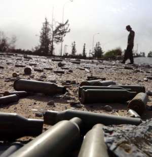 Spent bullet shells litter the ground as a member of the Islamist-linked militia of Misrata walks past following three days of battles in the area of Tripoli's International airport, on August 21, 2014.  By Mahmud Turkia AFP