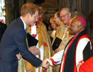 Britains Prince Harry (L) shakes hands with South African Archbishop Desmond Tutu as he arrives at Westminster Abbey in London on March 3, 2014 for a memorial service for former South African president Nelson Mandela. By John Stillwell (Pool/AFP)