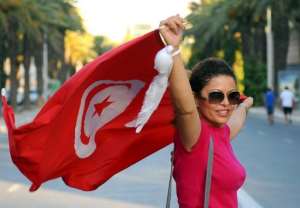 A Tunisian woman holds her national flag in Tunis,.  By Fethi Belaid AFPFile