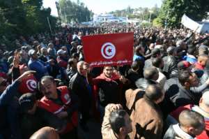 Tunisian policemen wave the national flag and shout slogans during a demonstration outside Tunis' Carthage Palace on January 25, 2016.  By Fethi Belaid AFP