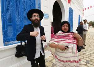 A Jewish pilgrim meets with Rabbi Israel outside the Ghriba synagogue, the oldest in Africa, on the island of Djerba on May 18, 2014.  By Fethi Belaid AFPFile