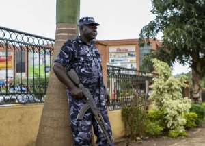 A Ugandan police officer stands guard outside a mall in Kampala on March 26, 2015.  By Isaac Kasamani AFP