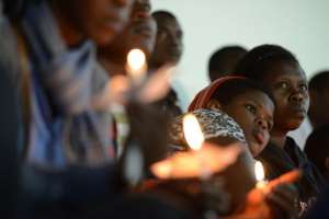 Rwandan women hold candles during a night vigil and prayer in Kigali on April 7, 2014, for the 20th anniversary of Rwanda's genocide.  By Simon Maina AFPFile