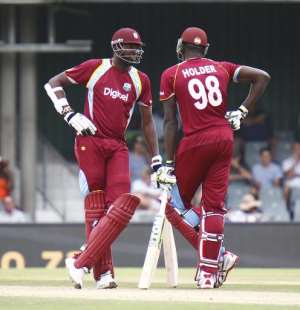 Sulieman Benn of the West Indies L and teammate Jason Holder chat during the third one-day international ODI at the East London cricket ground in East London, South Africa on January 21, 2015.  By  AFPFile