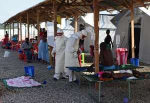 Nurses wearing personal protective equipment treat ebola patients at the Kenama treatment center run by the Red Cross Society on November 15, 2014.  By Francisco Leong AFPFile