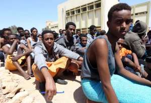 Migrants from sub-Saharan Africa sit at a center for illegal migrants in the al-Karem district of the Libyan eastern port city of Misrata on April 15, 2015.  By Mahmud Turkia AFP