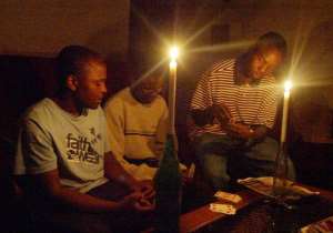 A Zimbabwean family plays card 21 January in Harare after a power cut.  By Desmond Kwande AFPFile