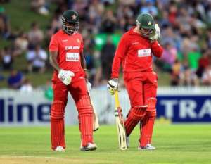 Zimbabwe's Brendan Taylor R and Elton Chigumbura during the second T20 international against N.Z..  By Marty Melville AFP