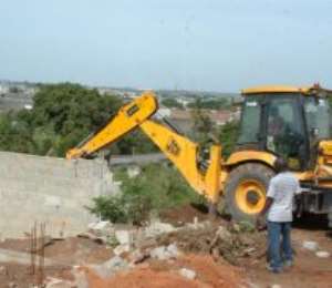 A bulldozer destroying the illegal structures