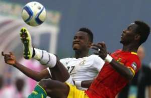 Baba Rahman L of Ghana fights for the ball with Guinea's Mohamed Lamine Yattara during their quarter-final soccer match of the 2015 African Cup of Nations