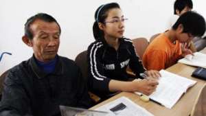 Xu Dahui takes her father to class to take care of him alongside her studies