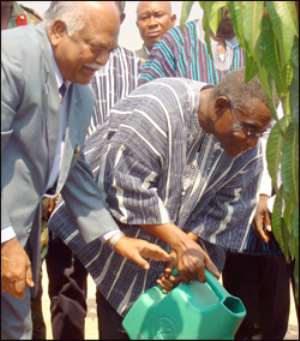 Mills being assisted by MD to plant a commemorative tree