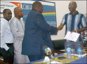 Hon.Kennedy Agyepong (r) pesenting his cheque to officials of World Vision Ghana