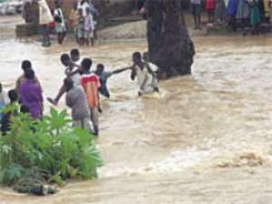 Children trying to cross the flood waters after school at Yamoransa                        