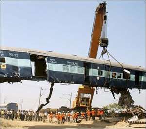 A crane lifts a damaged coach