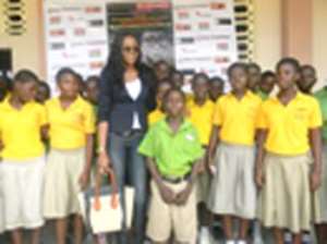 Yvonne Nelson poses for a photo with some school children