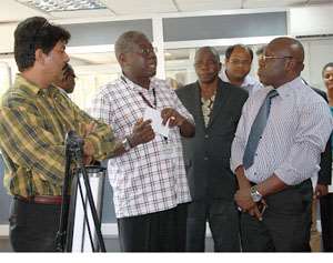 Reuben Damptey 2nd left, explaining a point to Inusah Fuseini in tie during a tour of some facilities at PMMC.
