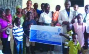 A group photograph of some beneficiary children, Mr Samuel Paulos; Dr Lawrence Sereboe and others.