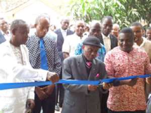 Mr. Godfred Medicene supporting Rev Mensah to cut the tape to inaugurate the new office complex