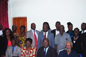 Faculty membersseatedand flanked by some of the stakeholders