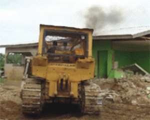 One of the 80 houses being demolished by a bulldozer.