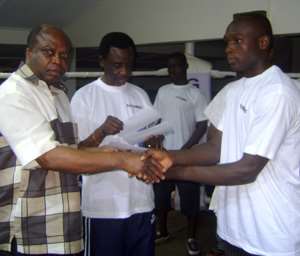 Hon Humado(L) presents Bawowe with his cash prize. With them is Ray Quarcoo