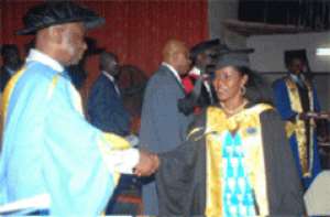 Mr Kofi Opoku Manu, Ashanti Regional Minister, congratulating Miss Harriet Tuffuor who received First Class Honours in Banking and Finance. She also won the overall student award.