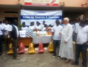 Union Savings and Loans MD, Philip Mensah (third from right) interact with Father Andrew Cambell (in white robe) after the donation as some officials of the Union looks on