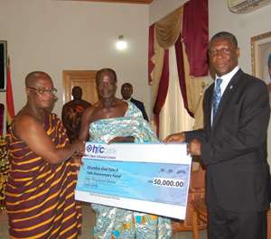 Mr Asare Akuffo presenting the cheque to some lieutenants of the Asantehene