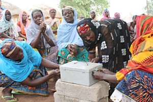 Women unlock their safe to collect and distribute loan money to the rest of their microfinance group. Photo by Mikaele SansoneCRS