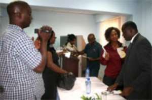 Mr Duncan (right)  interracting with some members of the media after the launch of the Media online trade show