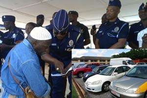 DCOP Kofi Boakye explaining the road traffic laws to a vehicle owner, INSET: Some of the impounded vehicles.