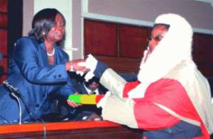 Mrs Georgina Theodora Wood (left) presenting the instrument of office to Rosita Bernasko-Essah a High Court judge, at the ceremony.